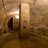 ...e volta a botte alta circa 3,30 metri. L�ambiente � diviso da due archi trasversali in tre campate e scandito da quattro pilastri